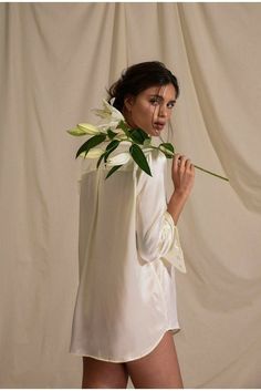 a woman in white shirt and shorts holding flowers