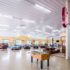 a car showroom filled with lots of furniture and cars parked in the garage area