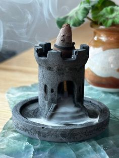 Elevate your space with this handcrafted black concrete medieval castle cone incense holder. Featuring a mesmerizing cascading and pooling smoke effect, this unique incense burner will bring an enchanting atmosphere to any room. This product is designed for use with "backflow" incense cones to create a cascading smoke effect but can also hold standard incense cones. Dimensions: Height: 2 inches Base Diameter: 2.5 inches Material: Concrete Color: Matte black with rustic medieval detailing. Note: Cone Incense Holder, Backflow Incense Holder, Black Concrete, Backflow Incense Burner, Cone Incense, Incense Cone, Backflow Incense, Concrete Color, Incense Holders