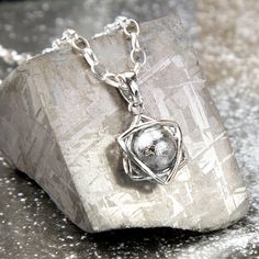 This Meteorite Orb and Star Necklace gives you a chance to carry a little slice of space with you wherever you go. For the person who has everything this unique pendant will highlight your individual style with a piece of natural history round your neck. Consisting of a free spinning orb of meteorite caged in a stylish star shaped silver pendant this makes a beautiful piece of jewellery and an a talking point all in one!. If you've ever yearned to own something from out of this world, here's your chance. Over 100,000 years ago, a handful of these mysterious Muonionalusta meteorites impacted earth. Searches for the impact crater from the original shower have been in vain; the site where these specimens are found is in a remote area of northern Sweden, it is presumed they were carried there