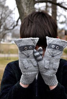 a boy with his hands in mittens covering his face