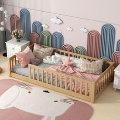 a child's bed with pink and blue walls in the background, an elephant rug is on the floor