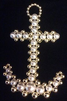 a cross made out of pearls on a black background