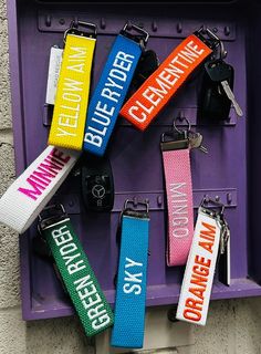 several different colored key chains hanging on a purple box with the words believe, believe, believe