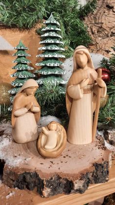 a nativity scene with figurines in front of a christmas tree