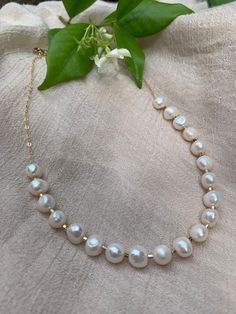 "This gorgeous necklace showcases a neckline of white Freshwater Pearls on a 14K Gold-filled chain. Beaded with small gold-filled accent beads in between each pearl. This beauty lets the iridescence of pearls take charge.  * Wear solo or layer with more of your favorite necklaces for the ultimate layered look.  * Necklace measures 16\" with 2\" extender chain. Finished with Gold-filled Lobster clasp.  * Reach out with any questions." White 14k Gold Filled Jewelry For Anniversary, Elegant White 14k Gold Filled Jewelry, White Pearl Necklace With Adjustable Chain, Yellow Gold Single Strand Necklace For Wedding, White Single Strand Necklace For Wedding, White Single Strand Pearl Necklace With 14k Gold Filled, Elegant White Pearl Necklace In 14k Gold, White Round Necklace With Adjustable Chain, White Pearl Necklace With Delicate Chain For Formal Occasions