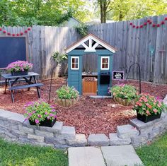 a small garden shed with flowers in it