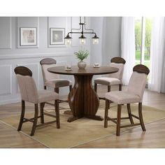 a dining room table and chairs with a rug on the floor in front of it