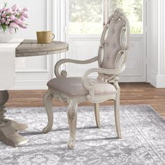 a dining room with a table, chairs and flowers in vases on the table