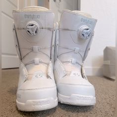 a pair of white snow boots sitting on top of a floor