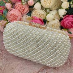 This luxurious encrusted pearl bridal clutch never fails to turn heads with its understated elegance and classic design. Adorned with varying sized ivory pearls and enhanced with a large creamy pearl clasp, this bridal clutch is the very picture of refinement. This elegant bridal clutch features rose gold trim, attachable chain and large enough for your phone. Complete your list of must-have wedding accessories with the ultimate bridal accessory to finish off your look and storing your wedding d Elegant White Evening Bag With Pearl Handle, Gold Pearl Evening Bag For Events, Elegant Pearl White Clutch For Events, Elegant White Clutch For Events, Elegant Pearl White Clutch Evening Bag, Gold Pearl Clutch For Parties, Elegant Pearl-embellished Evening Bag For Formal Occasions, Elegant Pearl White Rectangular Evening Bag, Elegant Pearl White Evening Bag For Formal Occasions