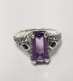 "Thanks for shopping our vintage estate store. We tend to sell well below wholesale and truly hope you enjoy all of our items. Many of the items are one of a kind, so please enjoy scrolling through the pictures and hopefully something will catch your eye. Estate sterling silver 925 natural 1ct amethyst emerald cut .15ct sapphire filigree ring. Beautiful ring, one that was custom made in our shop, meaning we set the gems into the setting. Ring size: 6 or 7 please select Setting: 1/2\" by 3/8\" 9mm Band width: 1.5mm Weight: 3.10 grams Beautiful ring one that you will love. Gems testing natural, but maybe created." Vintage Amethyst Ring With Accent Stones For Anniversary, Classic Amethyst Gift Ring, Classic Amethyst Ring With Vs Clarity As A Gift, Vintage Emerald Cut Amethyst Ring Gift, Vintage Emerald-cut Amethyst Ring For Anniversary, Vintage Emerald Cut Amethyst Ring For Anniversary, Antique Amethyst Ring Stamped 925 For Anniversary, Vintage Purple Amethyst Ring Stamped 925, Classic Purple Rings Stamped 925