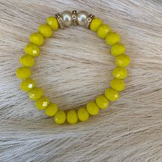 Introducing our stunning Yellow Faceted Rondelle Glass Bracelet, a must-have addition to any jewelry collection. This beautifully crafted piece features a series of yellow glass beads that have been expertly cut into a Rondelle shape, creating a faceted surface that catches the light with every movement. The bright and sunny yellow color of the beads adds a cheerful touch to any outfit, making it perfect for wearing during the summer months. In addition to the yellow glass beads, the bracelet also includes two white pearls, which add a touch of elegance and sophistication to the overall design.  Crafted with care and attention to detail, this Yellow Faceted Rondelle Glass Bracelet with 2 white pearls is sure to become a favorite piece in your jewelry collection. It is versatile enough to b Faceted Beads Stretch Bracelet, Elegant Rondelle Beaded Bracelets With Colorful Beads, Elegant Rondelle Beaded Bracelets, Elegant Adjustable Charm Bracelet With Colorful Beads, Adjustable Jewelry With Faceted Beads, Adjustable Faceted Beads Pearl Bracelet, Adjustable Round Jewelry With Faceted Beads, Adjustable Round Faceted Beads Jewelry, Beaded Rondelle Bracelets Ideal As Gifts