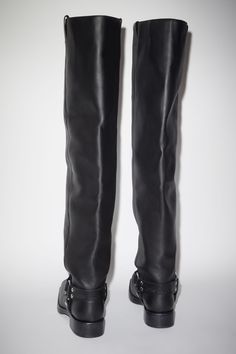 Acne Studios black high boots are crafted from leather, adorned with silver-toned metal hardware accents. Complete with stirrup strap details and debossed Acne Studios logo on the back. Leather Knee-high Moto Boots With Rivets, Edgy Leather Knee-high Boots With Buckle Closure, Leather Moto Boots With Buckle Closure For Riding, Leather Moto Boots With Buckle For Riding, Leather Biker Boots With Rivets, Biker Boots With Rivets In Leather, Biker Leather Boots With Rivets, Edgy Leather Knee-high Moto Boots, Black Calf Leather Boots With Rivets