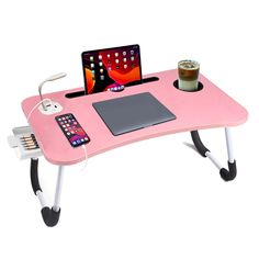 a pink desk with a laptop, phone and tablet on it