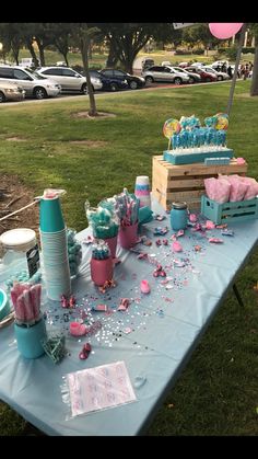 a blue table topped with lots of cake and confetti on top of it