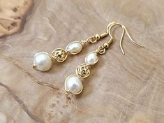 About this product: Our Freshwater Pearl Earrings are a dainty, opulent accessory that dangles lightly from your ears. Pearls are used as the main centerpiece to this lovely set. It is then accented by 14k Filigree Beads and 925 Gold Earring wires. We've made these earrings with lightweight and allergen-friendly materials, so you can have your own beauty naturally accented without sacrificing any comfort. This product will come in the displayed gift box along with a polishing cloth.   What we lo Elegant Gold Hypoallergenic Beaded Earrings, Elegant Gold Beaded Hypoallergenic Earrings, Elegant Wire Wrapped Beaded Earrings, Elegant Adjustable Wire Wrapped Earrings, Elegant White Hypoallergenic Beaded Earrings, Elegant Adjustable Hypoallergenic Beaded Earrings, Elegant Hypoallergenic Beaded Earrings With Round Beads, Hypoallergenic Round Pearl Beads Earrings For Wedding, Elegant Hypoallergenic Teardrop Beaded Earrings