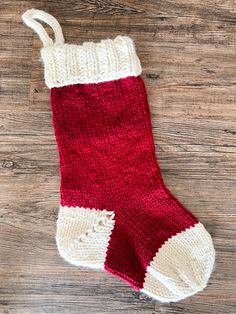 a red and white sock sitting on top of a wooden floor