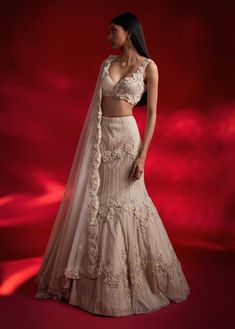 Step into sophistication with this ivory lehenga featuring exquisite 3D flower embellishments. The fish-cut silhouette, paired with a matching blouse and dupatta, creates a graceful and opulent look that's perfect for any elegant occasion. Elegant Cream Choli With Sheer Dupatta, Elegant Cream Lehenga With Pearl Embroidery, Designer Cream Organza Lehenga, Elegant Beige Choli With Sheer Dupatta, Elegant Designer Wear Off White Lehenga, Elegant Designer Off-white Lehenga, Elegant Cream Organza Lehenga, Cream Hand Embellished Lehenga For Reception, Elegant Designer Wear Off-white Lehenga