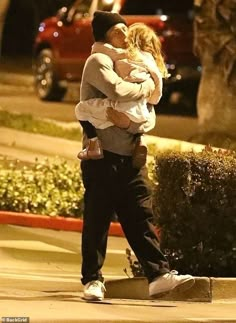 a man and woman hugging on the street