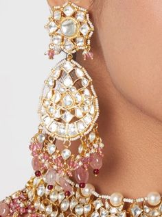 This exquisite Gold Plated Kundan with Pearl and Pink Stone Necklace Set features a stunning combination of pink and white stones, elegantly set in a silver alloy base and adorned with a delicate line of pearls. The set includes matching 22kt earrings, making it a perfect choice for Sangeet, Weddings or any special occasion. Matching Ring and Head Set Available from our Rings and Head Set Collection Composition: Silver Alloy and 22kt Gold Plated Care: Clean with soft dry cloth. Store in moisture Pink Stone Necklace, Earrings Matching, Stone Necklace Set, Traditional Indian Jewellery, Cloth Store, Head Set, Stone Choker, Indian Wedding Wear, Kundan Necklace