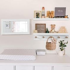 a baby's room with white furniture and decor on the wall, including a crib