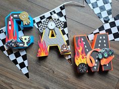 the letters are made out of paper and decorated with racing cars, trucks, and race flags