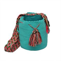 a turquoise colored bag with tassels on it