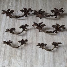 an assortment of ornate iron brackets on a wooden floor