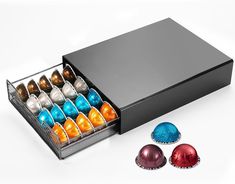 an open black box with six different colored balls in it and four silver ones on the side