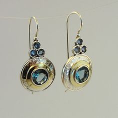 A wonderful new design hanging earrings. Elegant NEW pair of earrings in round shape from my collection with 8mm round Blue Topaz inlaid in 15mm diameter 925 solid silver, framed with 2mm wide 9K polished solid yellow gold. Also, these hanging earrings has three tiny Blue Topaz CZ that give them charming look. These are great new design pair of earrings, don't miss! Drop/Dangle earrings, fits any occasion. Will upgrade any look and show your unique fashion style. Perfect Gift for you and your lo Nickel Free Blue Topaz Drop Earrings, Fine Jewelry Blue Topaz Round Earrings, Elegant Blue Topaz Earrings With Ear Wire, Blue Topaz Round Pierced Earrings, Hallmarked Round Blue Topaz Earrings, Elegant Nickel-free Blue Topaz Earrings, Elegant Blue Topaz Nickel-free Earrings, Pierced Blue Topaz Round Earrings, Pierced Round Blue Topaz Earrings