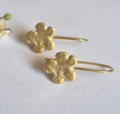 Beautiful gold or sterling silver flower earrings, dainty and minimalist jewelry earrings for girls and women, available in 14k quality gold plating, sterling silver, and solid gold.  These drop earrings are romantic and delicate. The earrings were carved in wax and later cast in metal. They are available in sterling silver, high-quality 14k gold plating, 9k solid yellow gold, and 14k solid yellow gold. These earrings are elegant and lightweight. They will be perfect for a minimalist, delicate l Gold Flower Charm Earrings As A Gift For Her, Gold Earrings With Flower Charm As Gift For Her, Gold Earrings With Flower Charm For Her, 14k Gold Earrings With Flower Charm For Gift, Gold Plated Dainty Earrings With Flower Charm, Dainty Flower Earrings As Gift For Her, Dainty Gold Plated Earrings With Flower Charm, Delicate Flower Shaped Gold Plated Earrings, Dainty Gold Flower Earrings As A Gift For Her