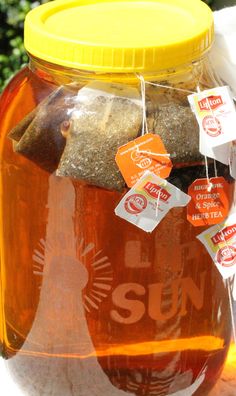 a jar filled with lots of food sitting on top of a table next to a tree