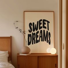 a poster that says sweet dreams on the wall above a bed