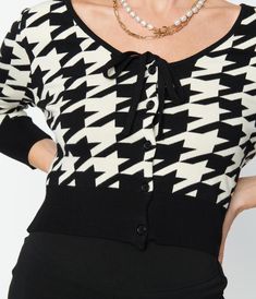 This sweet cardigan is crafted in a fabulous knit blend and boasts a gorgeous black and ivory houndstooth design. The button up front leads to a classic V-neckline, centered by a sweet self tie bow. The slender three-quarter length sleeves drop into a ribbed cuff while the stay in place hem makes this a charming coverup!Available in sizes XS-5X while supplies last. Uv Clothing, Cardigan Outfits, Rockabilly Fashion, Vintage Cardigan, Tie Bow, Plus Size Sweaters, Inspired Dress, Retro Outfits, Dandy