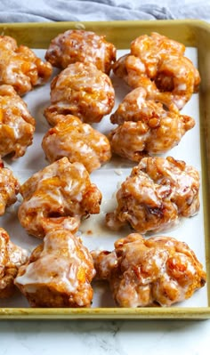 a tray filled with glazed donuts covered in icing