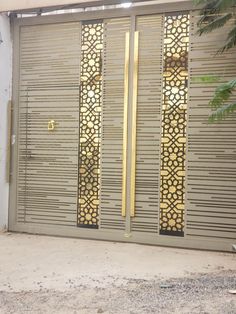 an entrance to a building with metal doors and decorative designs on the side walk way