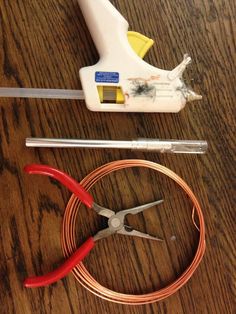 some tools are laying out on a wooden table with wires and pliers next to them