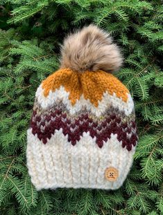 a knitted hat with a pom - pom sitting on top of a tree