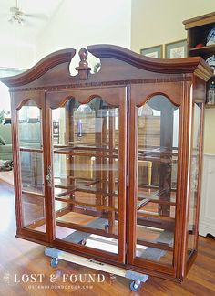 an antique china cabinet with glass doors in a living room