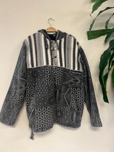 "Handcrafted : Each jacket is a unique creation by Nepali artisans, featuring vibrant patterns and intricate stitches. Unisex and Versatile: Suitable for everyone, perfect for both outdoor cold and indoor comfort. Eco-Friendly Comfort: Made from 100% cotton, offering breathability and coziness with added pockets for convenience. Additional Front Pocket included. Each purchase supports the skilled hands that bring these jackets to life, fostering sustainable practices and empowering communities in Nepal. Sizing Small(S) : Chest: 21\" | Length: 26\" | Shoulder: 18\" |  Sleeve Length: 22.5\"   | Arm Hole: 10\" Medium (M): Chest: 22\" | Length: 27\" | Shoulder: 18.5\" |  Sleeve Length: 23\" | Arm Hole: 10.5\" Large(L): Chest: 23\" | Length: 28\" | Shoulder: 19\" | Sleeve Length: 23.5\"   | Arm Bohemian Hooded Top For Fall, Black Bohemian Hoodie, Bohemian Hooded Hoodie For Festivals, Traditional Winter Festival Tops, Bohemian Cotton Hoodie For Festival, Bohemian Winter Festival Hoodie, Bohemian Patchwork Tops For Winter, Bohemian Hoodie For Festivals, Bohemian Black Hooded Hoodie