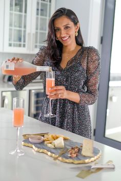 a woman pouring a drink into a glass