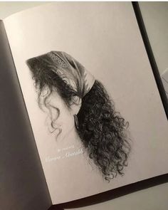 an open book with a drawing of a woman's head on top of it