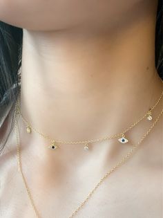 Evil Eye Charm Choker, dainty Evil Eye CZ Charm Choker Necklace is designed to provide strength and protection from negative energy. Layer this choker with anyone of our necklaces or wear it alone, either way you are guaranteed good vibes. * Round Brilliant Cubic Zirconia Stones * 18k Yellow Gold Plated or Rhodium Plated Sterling Silver * Chain Length: Adjustable from 12 inches to 15 inches * Spring Clasp Closure. Evil Eye Charm Necklace, Dainty Evil Eye Necklace, Neck Pieces Jewelry, Necklace Evil Eye, Choker Necklace Designs, Turkish Eye, Pretty Jewelry Necklaces, Charm Choker Necklace, Choker Gold