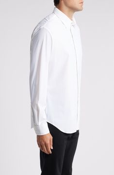 Soft, stretchy and all-day comfortable, this versatile white shirt smartly elevates any outfit and looks great whether you wear it tucked or untucked. 30 1/2" length; 44" chest (size Medium) Front button closure Spread collar Long sleeves with button cuffs 76% nylon, 24% elastane Dry clean Imported Elegant White Shirt With Shirttail Hem, Classic White Shirt With Shirttail Hem, Elegant Fitted Shirt With Shirttail Hem, Modern Formal Tops With Shirttail Hem, Formal White Top With Shirttail Hem, Modern Formal Top With Shirttail Hem, Classic Stretch Dress Shirt For Formal Occasions, Fitted Formal Tops With Shirttail Hem, Classic Stretch Shirt For Formal Occasions