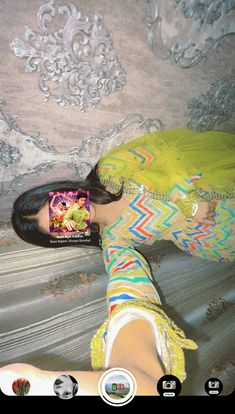 a woman laying on top of a bed next to a wall