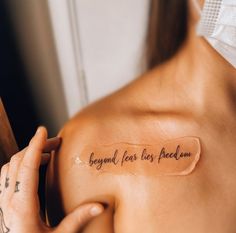 a woman with a tattoo on her shoulder that says, beyond fear lies reason behind