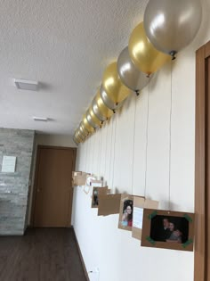 some balloons hanging from the ceiling with pictures on them and photos taped to the wall