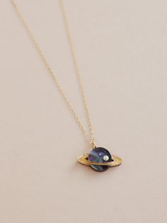 Did you know...sometimes it rains diamonds on Saturn! Our miniature version of this magical planet comes in marbled midnight acrylic, embellished with a high quality glass pearl & crystal. Purchase with a one of our chains or add the pendant onto one you already have. Photographed on a 45cm 14k gold-filled flat cab Celestial Round Jewelry For Parties, Space-themed Pendant Jewelry For Gift, Space-themed Pendant Jewelry Gift, Space-themed Gold Jewelry Gift, Handmade Cosmic Style Jewelry For Gifts, Cosmic Style Handmade Jewelry As A Gift, Handmade Cosmic Jewelry For Gifts, Iridescent Jewelry With Adjustable Chain For Gift, Iridescent Pearl Pendant Jewelry Gift