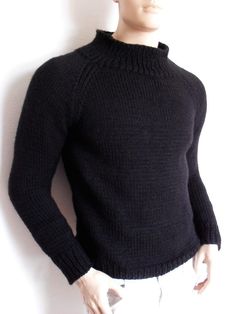 a male mannequin wearing a black sweater and white pants